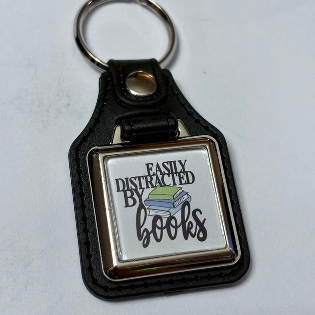 DISTRACTED BOOKS VINYL KEYCHAIN SQUARE