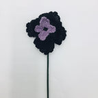 Black petals with violet petals and black french knots for a center