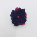Black, raspberry and purple petals with a raspberry french knot center