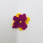 lime leaves, marigold and magenta petals with marigold french knot center
