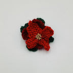 red and ruby petals over dark green leaves and gold tone beaded center
