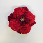 Ruby and red petals, dark green leaves and gold tone beaded center