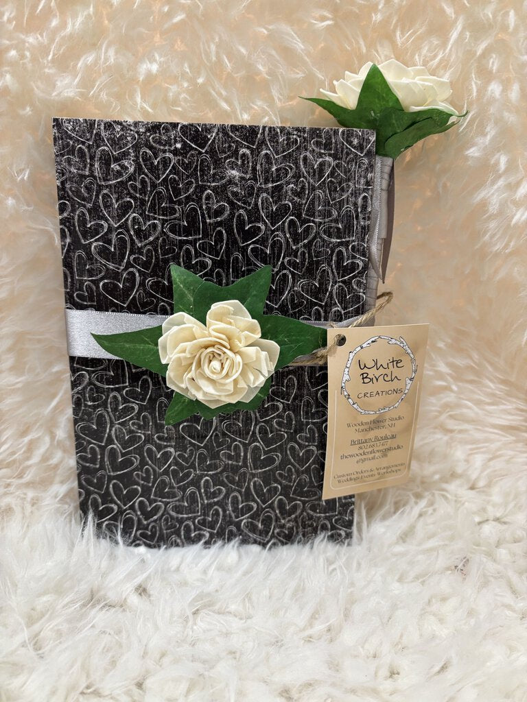 Notebook w/ pen featuring a soft close magnet in black with white hearts, white flowers with gray ribbon