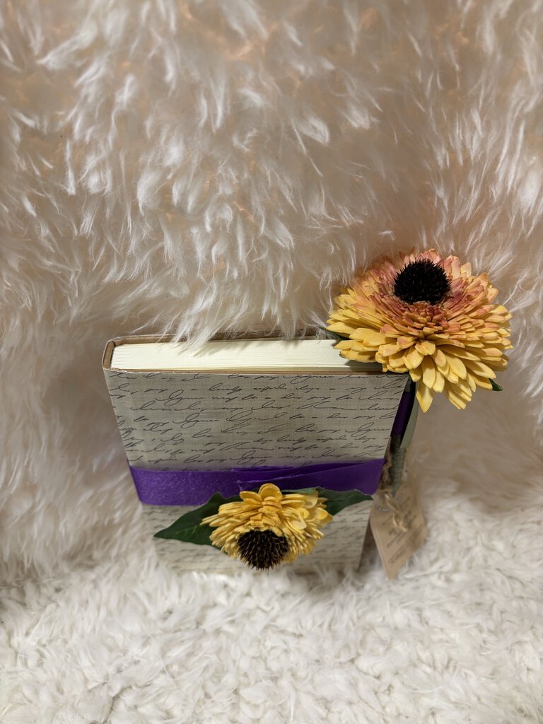 Notebook w/ pen featuring a soft close magnet in cream with writing and sunflowers with purple ribbon