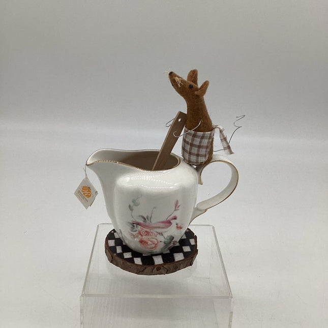 Small brown mouse on creamer making tea