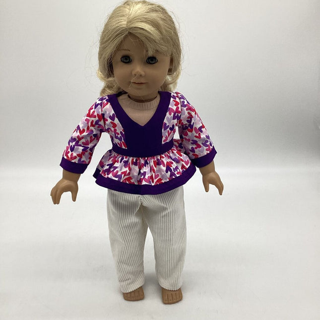 White top with multi colored hearts and purple details. White corduroy pants