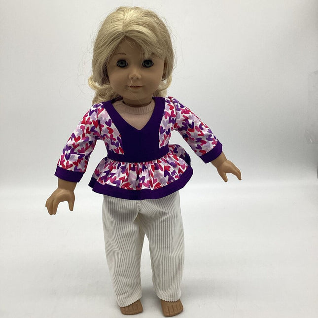 White top with multi colored hearts and purple details. White corduroy pants